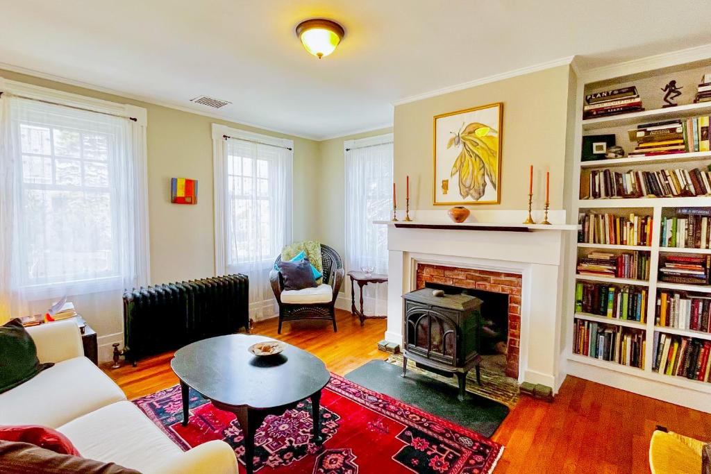 a living room with a fireplace and a table at Full of Light Cottage in Rockland