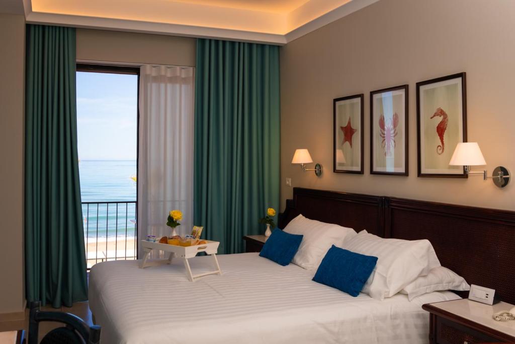 sypialnia z dużym łóżkiem i widokiem na ocean w obiekcie Hotel Schuhmann w mieście Paestum