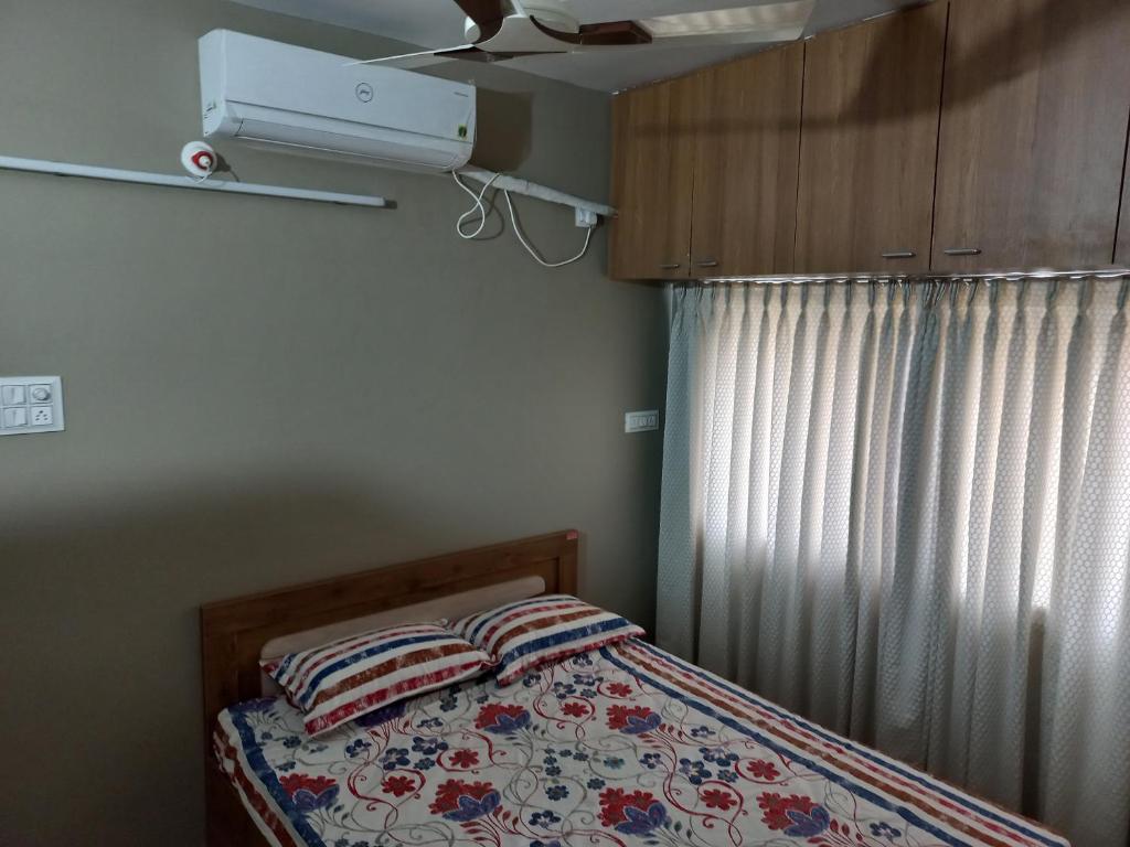 - une petite chambre avec un lit et un ventilateur dans l'établissement The Nest - Luxurious Landing, à Sāngli