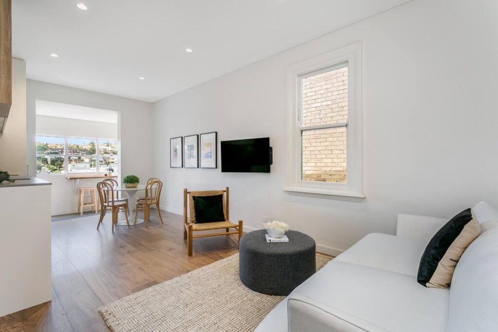 un soggiorno con divano bianco e tavolo di Coogee Beach 2 Bedroom Apartment - CG226 a Sydney