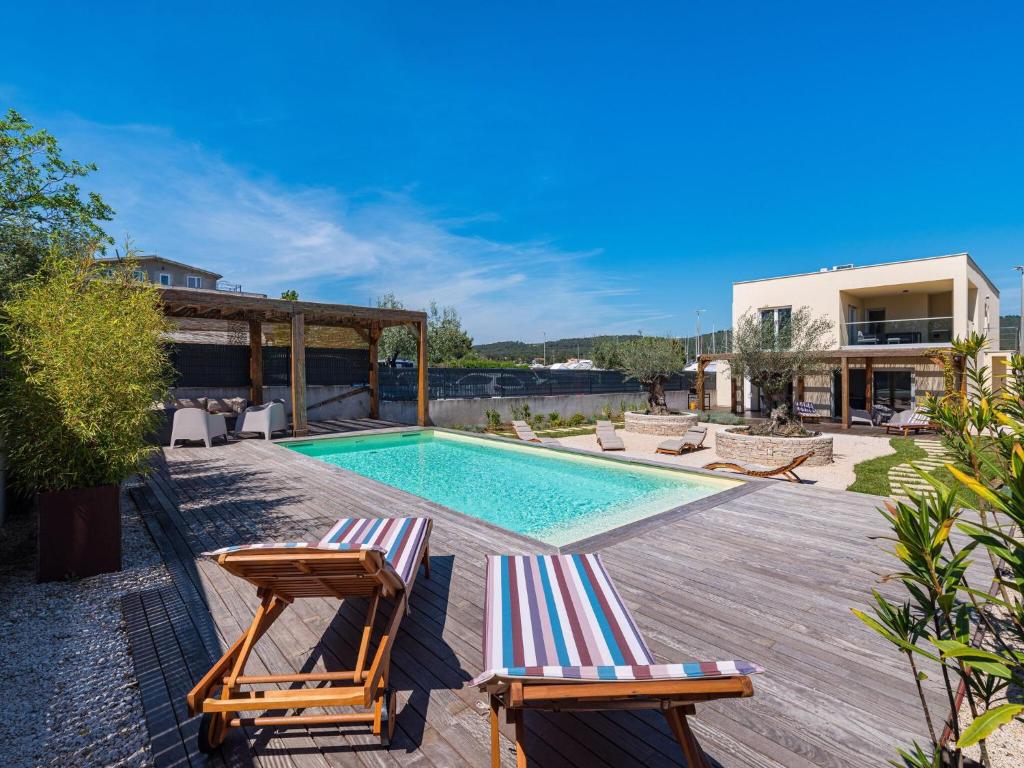 a villa with a swimming pool and two deck chairs at Villa in Bibinje with Private Pool and Garden in Bibinje