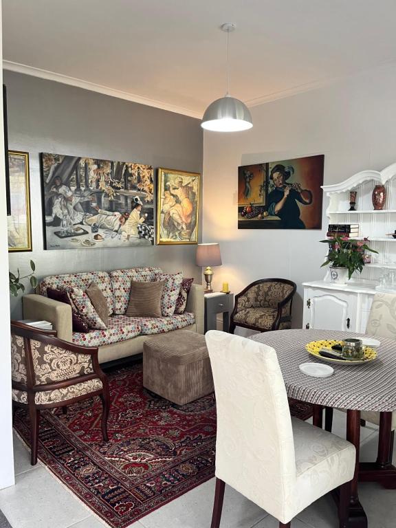 - un salon avec un canapé et une table dans l'établissement Somerset West Garden Apartments 1, à Somerset West