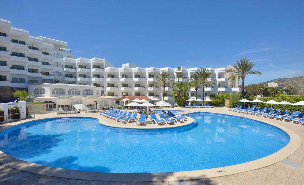 una gran piscina con sillas y un hotel en Sol Lunamar Palmanova Apartamentos - Adults Only, en Palmanova
