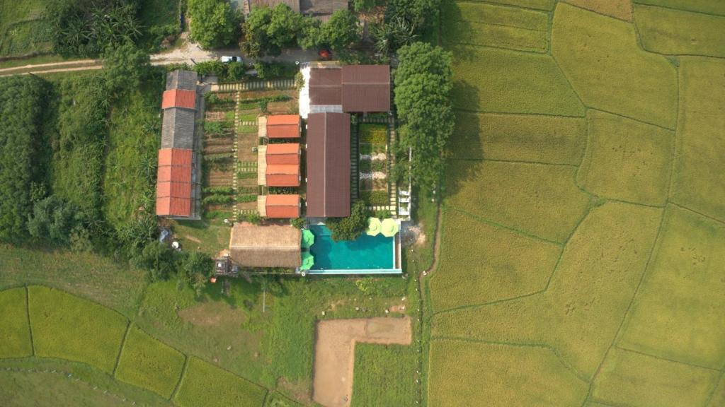an aerial view of a farm with a house and a pool at Greenfield Ecostay in Phong Nha