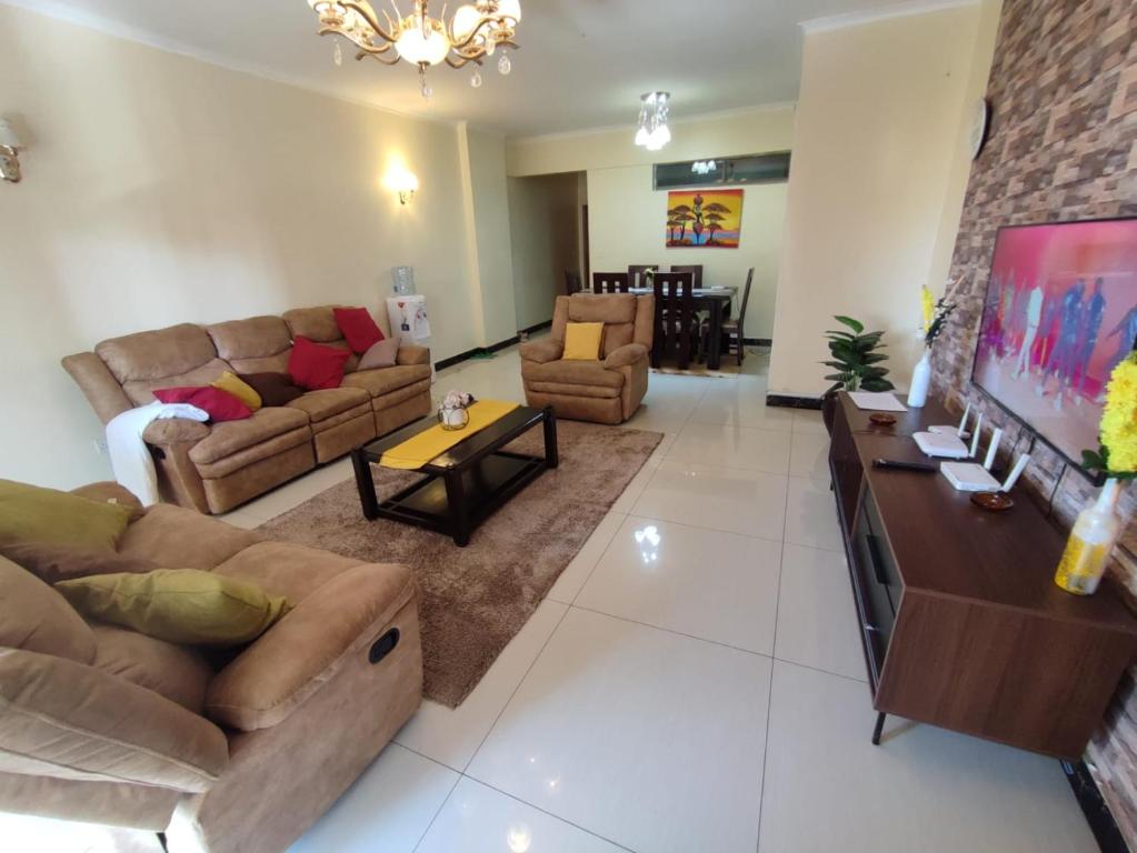 duży salon z kanapami i telewizorem w obiekcie Lux Suites Skyhorse Apartments Kilimani w mieście Nairobi