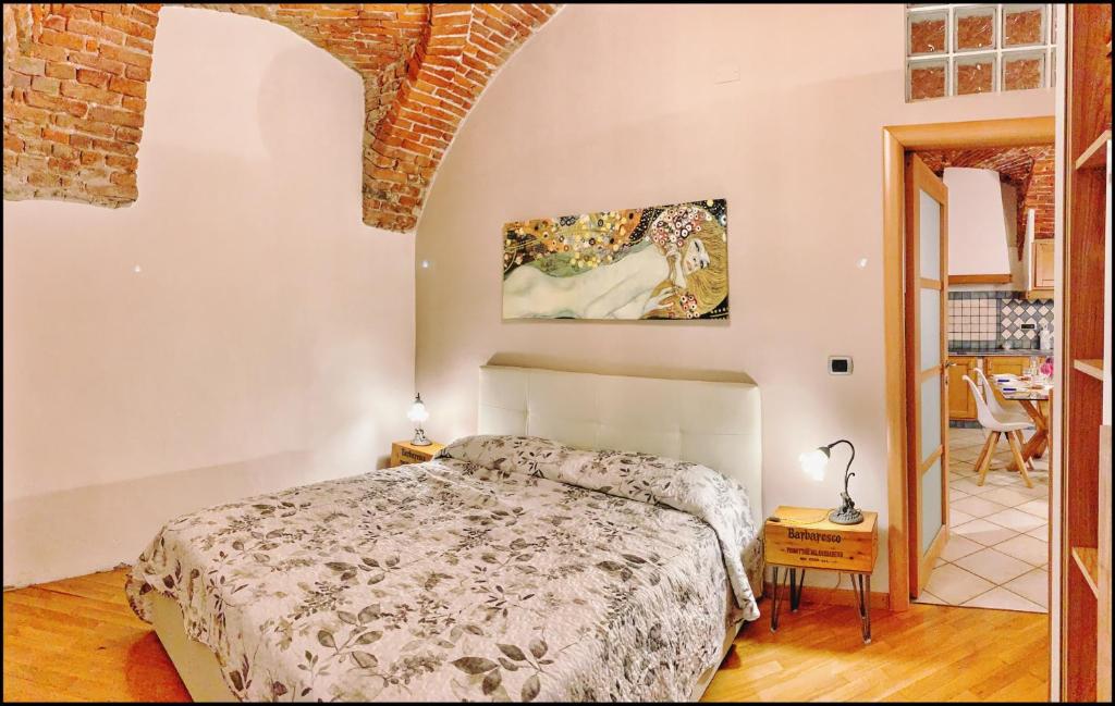 a bedroom with a bed and a table with a chair at La Fiaba: bilocale nel centro storico di Cuneo in Cuneo
