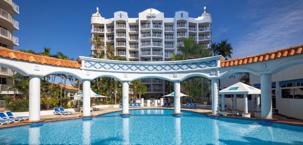 a swimming pool with a resort in the background at Bel Air on Broadbeach in Gold Coast