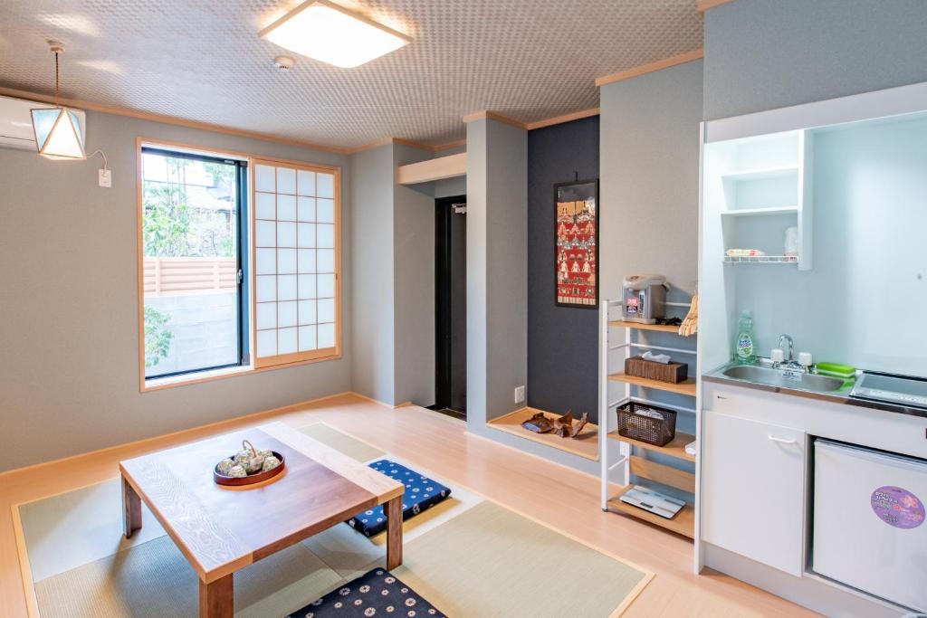 een woonkamer met een tafel en een raam bij Kyoto KaedeHotel Kamogawa in Shimmachidōri