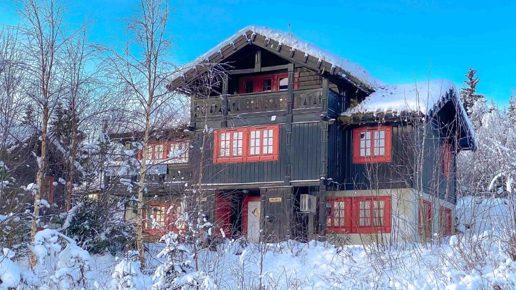 a building with red windows in the snow at Storsten 730 in Trysil