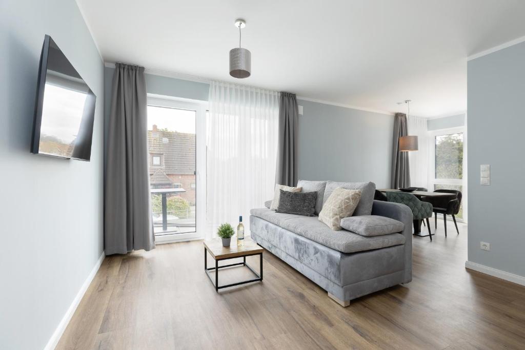 uma sala de estar com um sofá e uma mesa em Sturmfrei Suite 7 em Scharbeutz