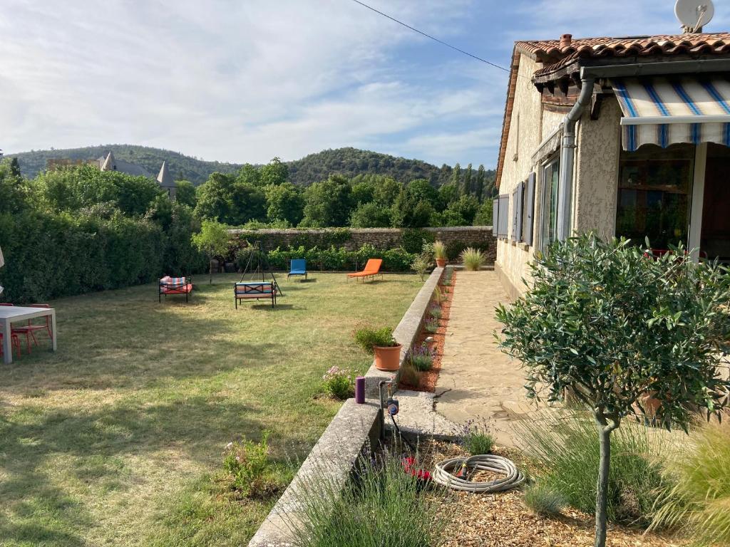 - un jardin avec un bâtiment, une table et des chaises dans l'établissement Petite Campagne au coeur des gorges du Verdon, à Allemagne-en-Provence