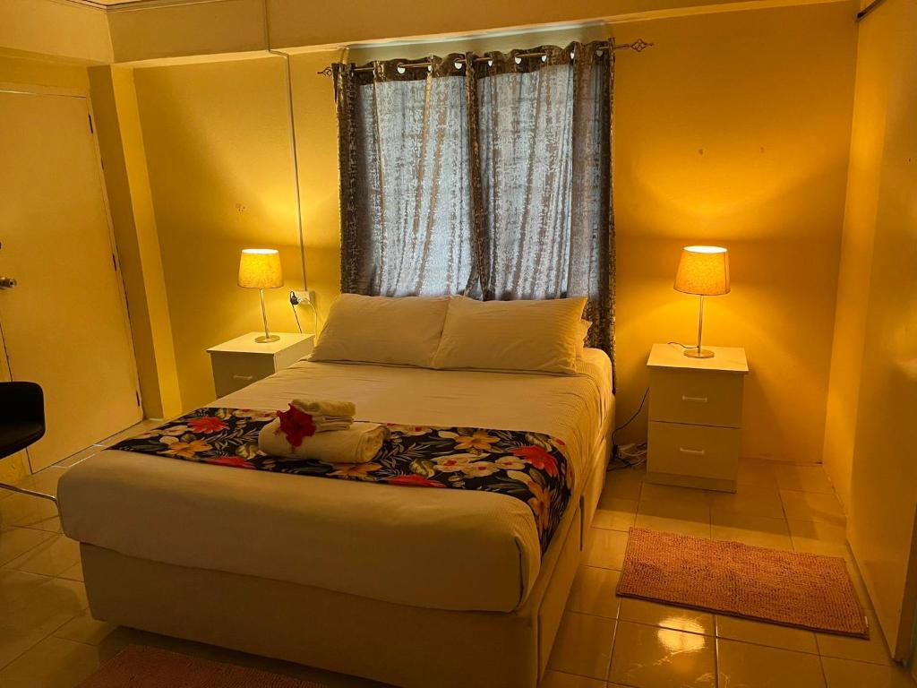 ナンディにあるLibby's Vacation Rental 2 Bed Home 1-4 Guestsのベッドルーム1室(ベッド1台、ランプ2つ、窓付)