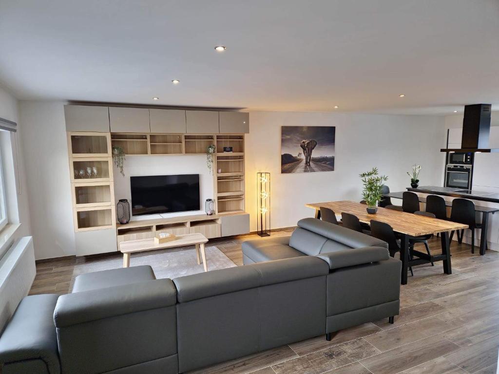 a living room with a couch and a dining room at le coin douillet in Saint-Ghislain