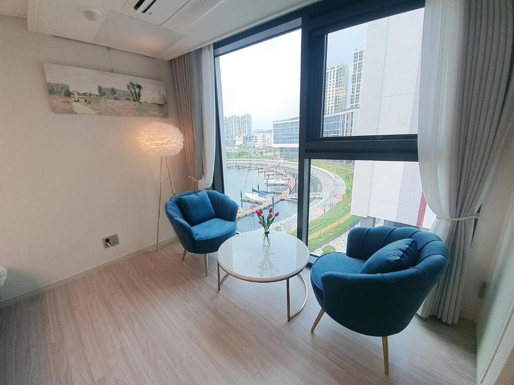 a room with two chairs and a table and a large window at Lotte Castle Marina in Yeosu