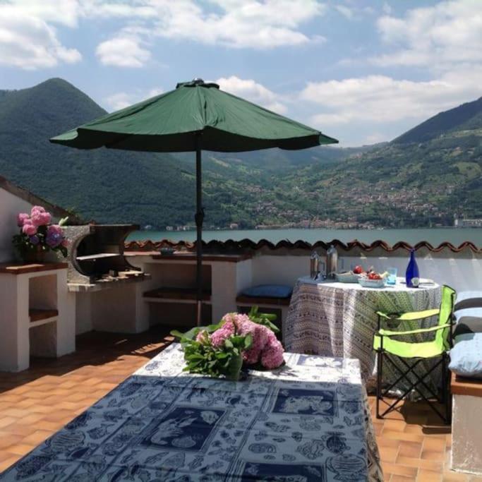 a table with a green umbrella on a deck at Baia dei Colori in Cure