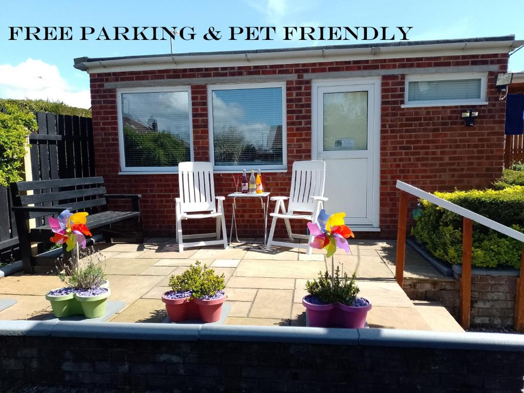 a patio with two chairs and a table with flowers at STUDIO PAD in Cardiff