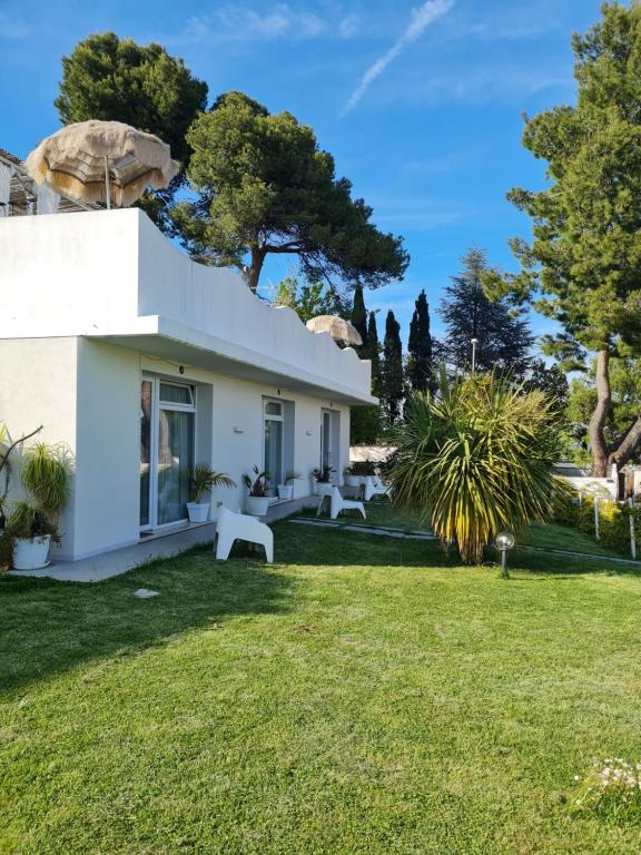 una casa blanca con un patio verde en Villa Tropical, en Francavilla al Mare