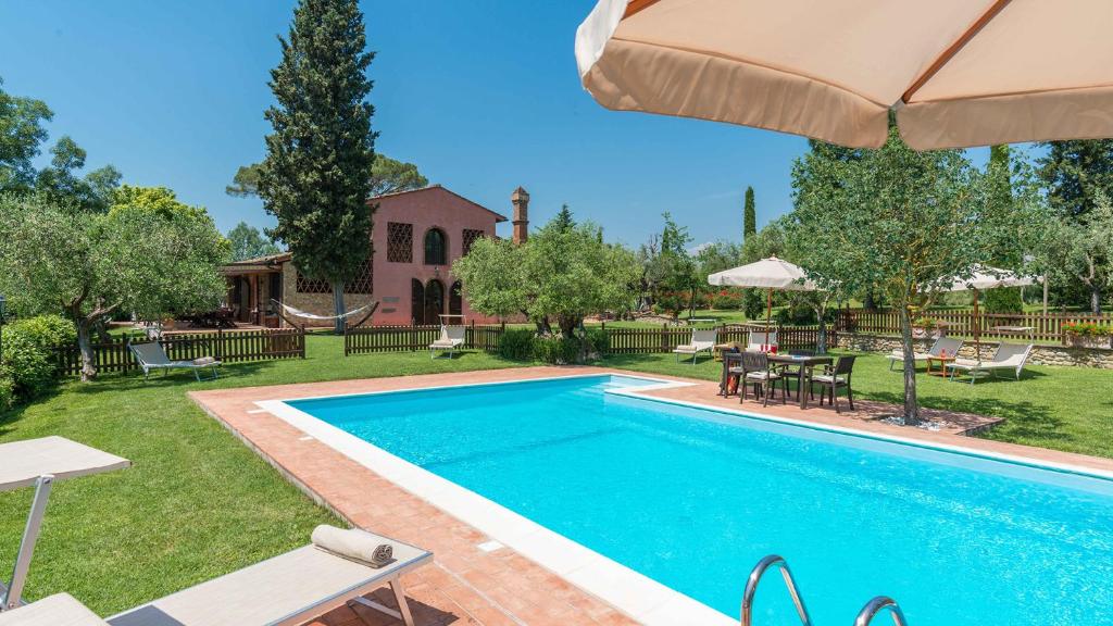uma piscina num quintal com um guarda-chuva em VILLA GINO 8&2, Emma Villas em Empoli