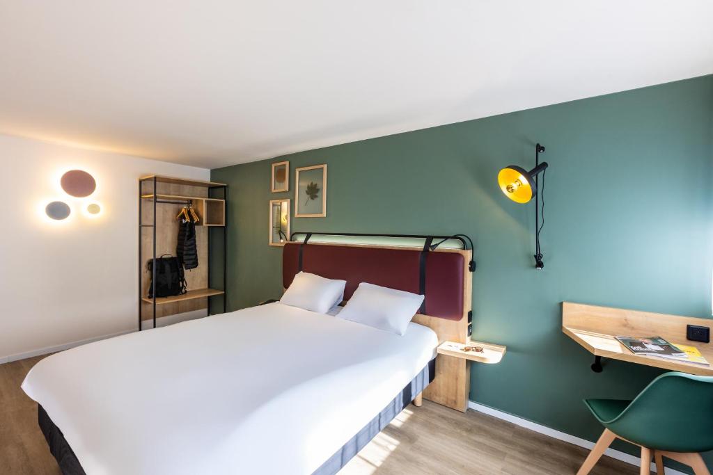 ピュイルボローにあるCampanile La Rochelle Nord - Puilboreau Chagnoletのベッドルーム1室(ベッド1台、デスク、椅子付)