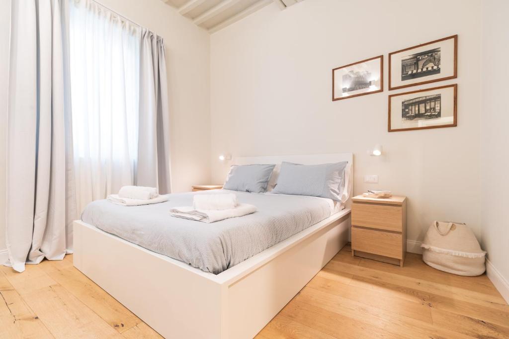 ein weißes Schlafzimmer mit einem weißen Bett und einem Fenster in der Unterkunft CasadiMaru in Pietrasanta