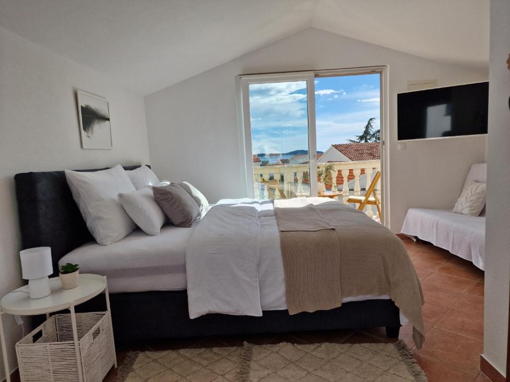 a bedroom with a bed and a large window at Villa SeaBreeze in Rogoznica