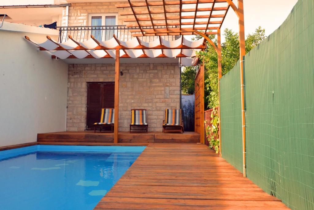 une pergola au-dessus d'une piscine dans une maison dans l'établissement Apartment Lucy by the sea with a private pool, à Kaštela