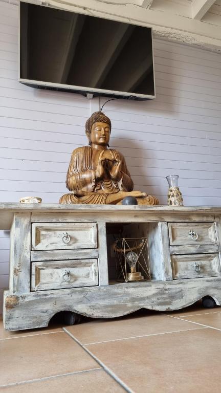 une statue d'une femme assise sur une commode dans l'établissement les gites d'EVANE 