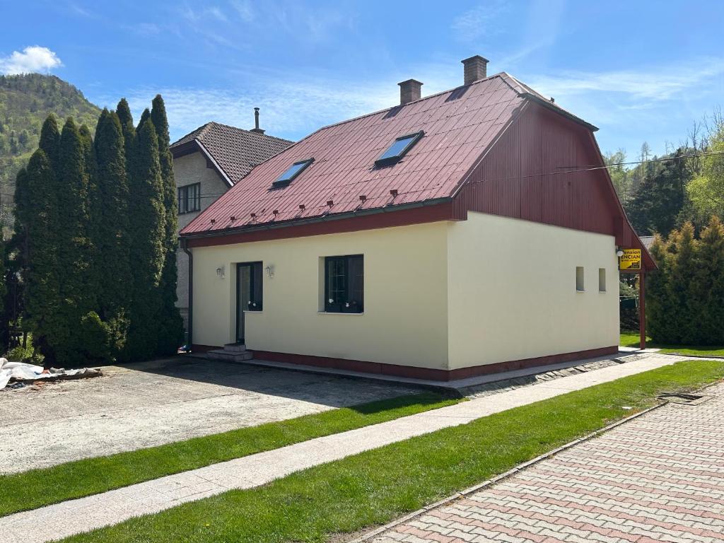 Casa roja y blanca con techo rojo en Penzión Encián en Blatnica