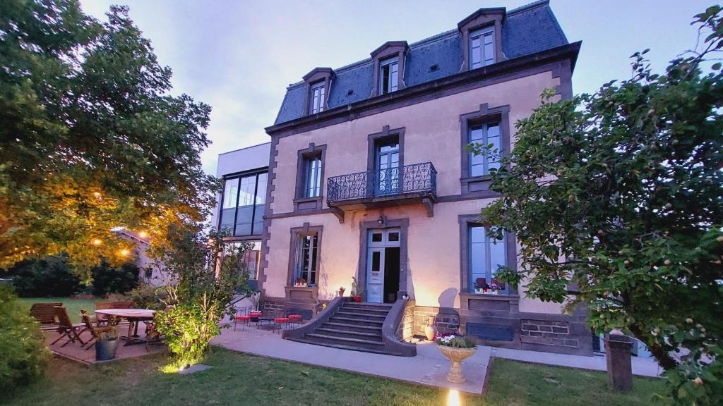 une grande maison rose avec un escalier en face de celle-ci dans l'établissement La Belle Epoque, à Cournon-dʼAuvergne