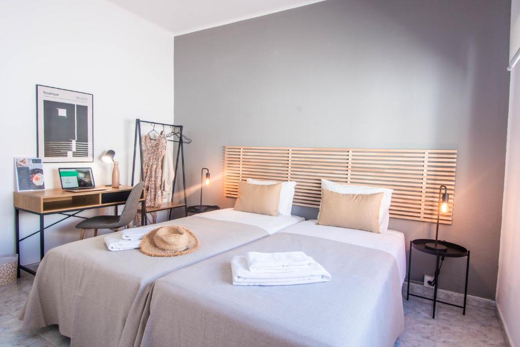 a bedroom with a large white bed with a hat on it at Virginia Guest House in Lagoa