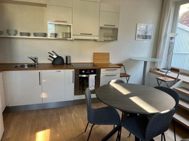 a kitchen with a table and chairs in a room at Marken Apartments in Bergen