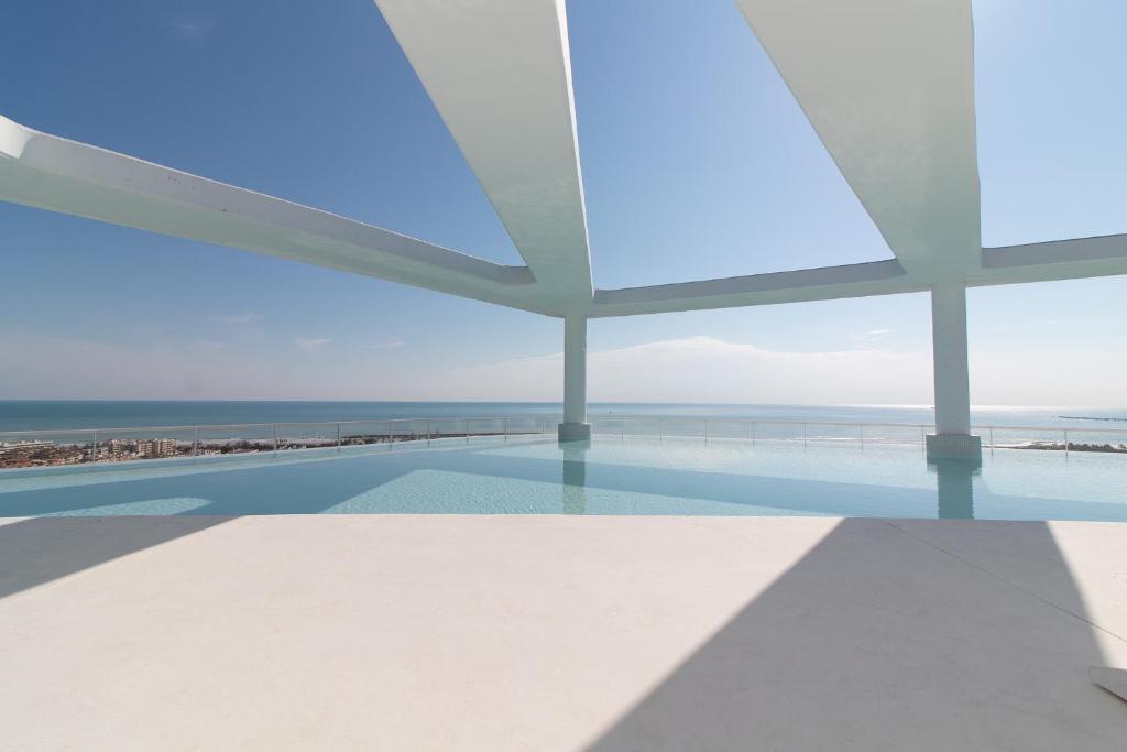 a swimming pool with a view of the ocean at Global Properties, Apartamento con terraza y vistas a la piscina en Gran Canet in Canet de Berenguer