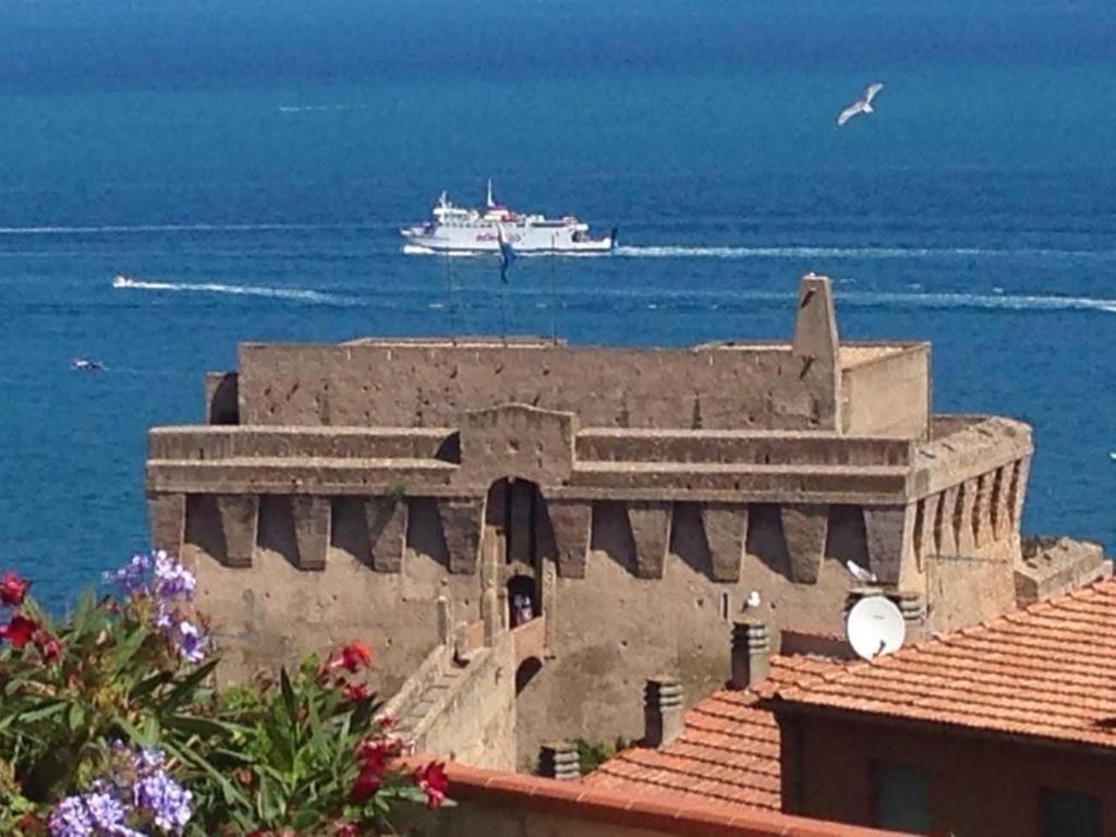 a cruise ship in the ocean with a building at appartamento vista mare in Porto Santo Stefano