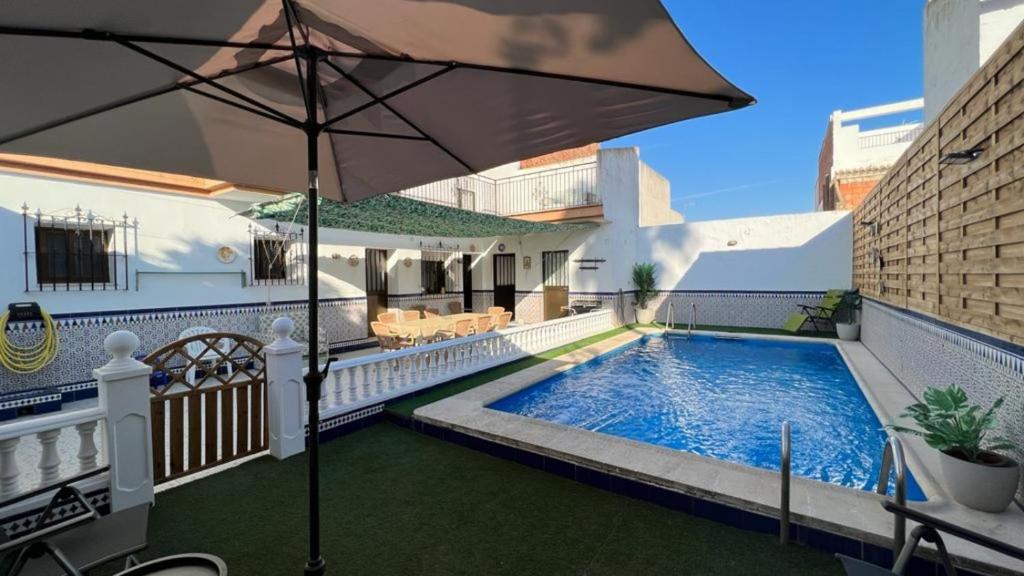 a house with a swimming pool and an umbrella at Villa Gení La Victoria by Ruralidays in La Victoria