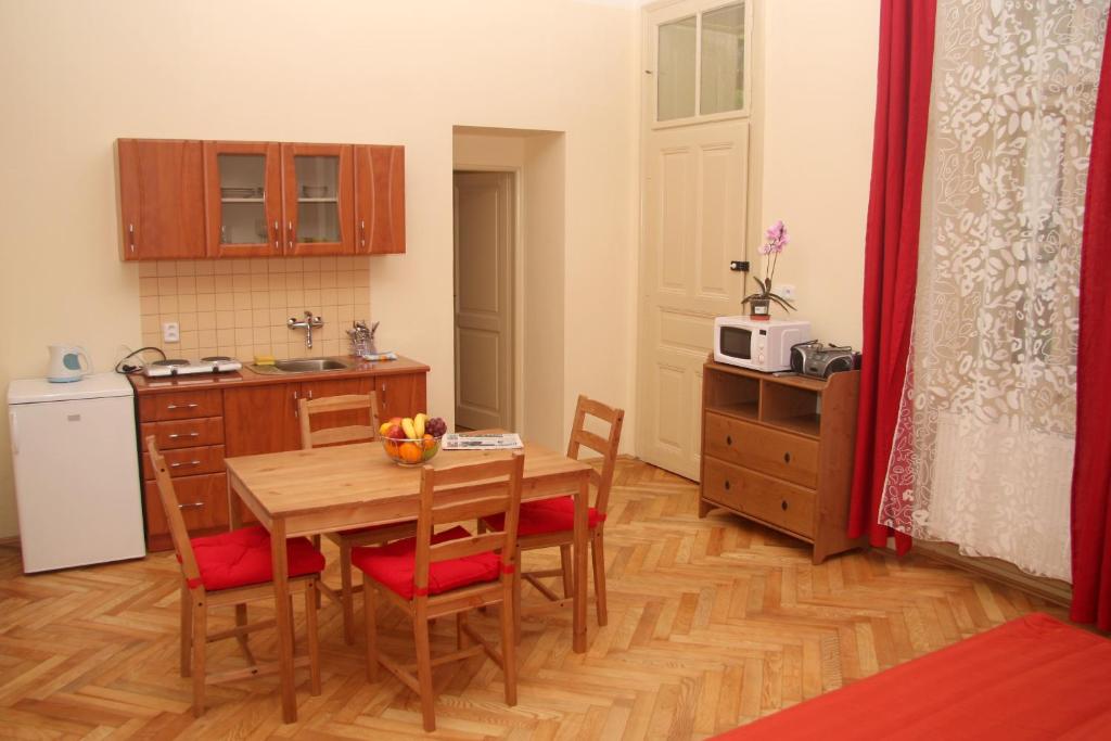 een keuken met een tafel en stoelen en een keuken met een magnetron bij Apartmán Husova 1.patro in Jičín