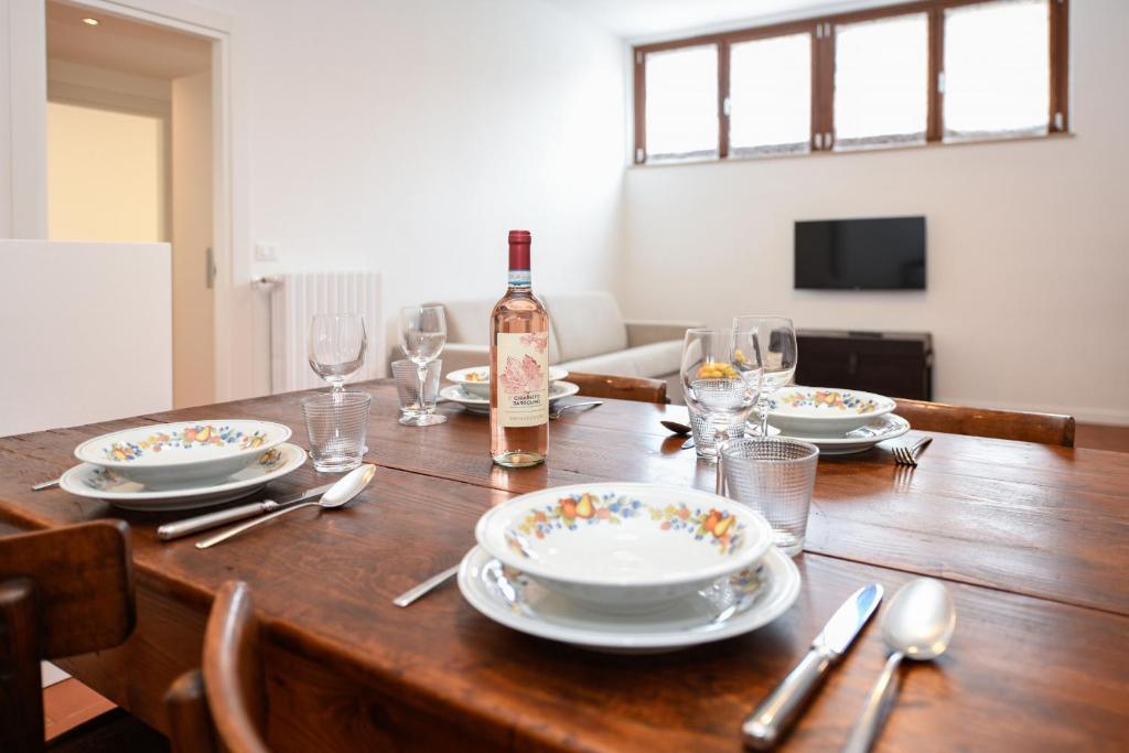a dining room table with a bottle of wine on it at Appartamento Isi in Salò