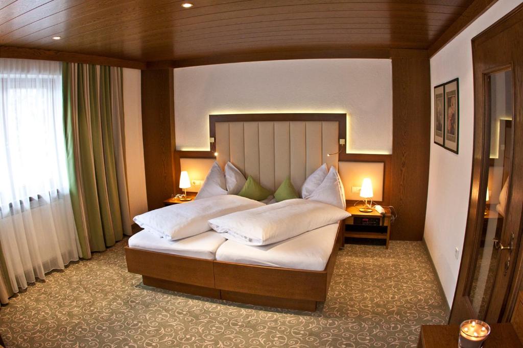 a bedroom with a large bed with white pillows at Hotel Garni Pra Posta in Ischgl