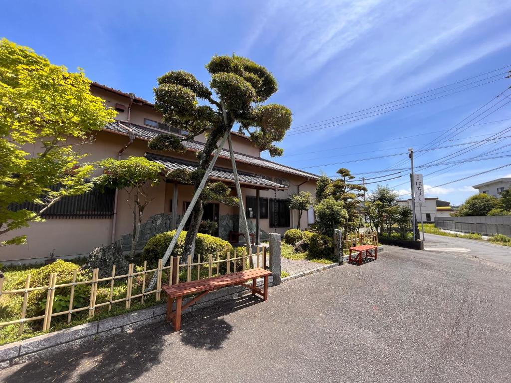 a bench in front of a house with a tree at Hachibosi in Makinohara