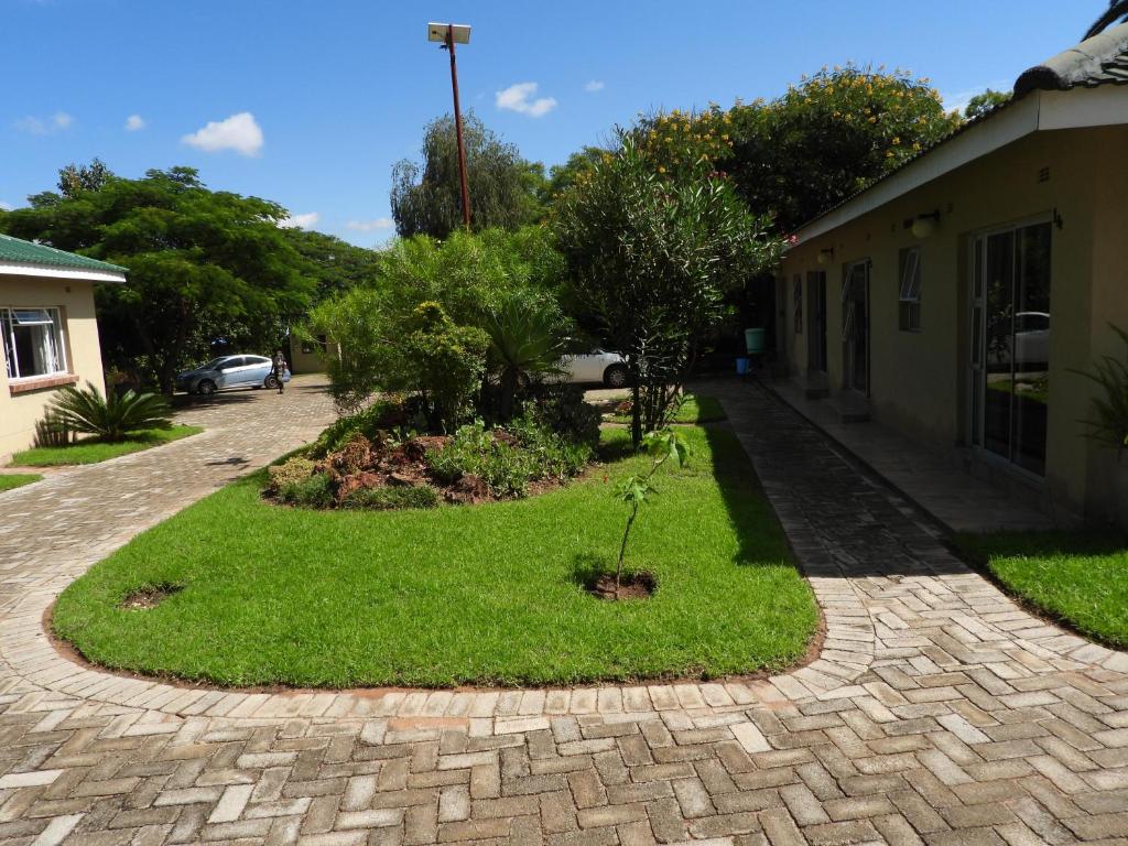 a brick driveway with a garden in the middle at 2 bedroomed apartment with en-suite and kitchenette - 2071 in Harare