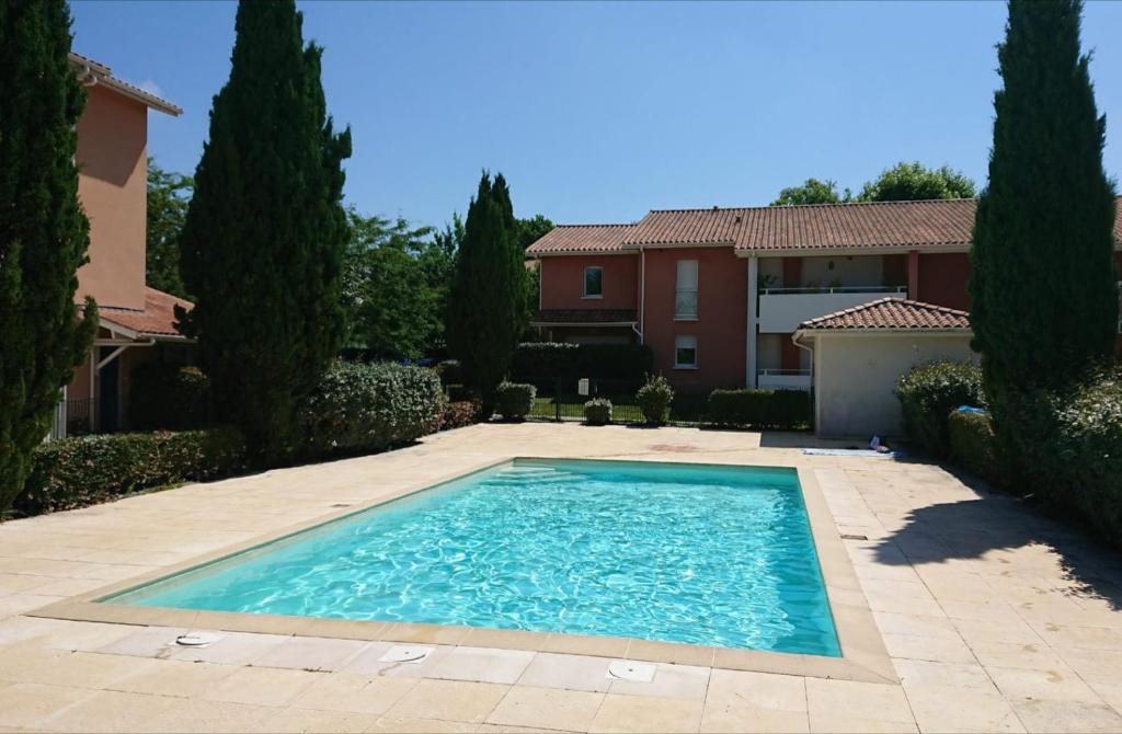 a swimming pool in front of a house at Res au calme et arboree in Dax