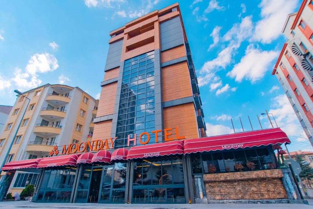 a hotel with a red awning in front of a building at MOONDAY HOTEL in Kayseri
