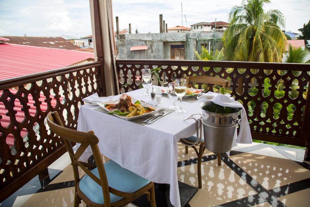 a table with a plate of food on a balcony at Spice Palace Hotel in Zanzibar City
