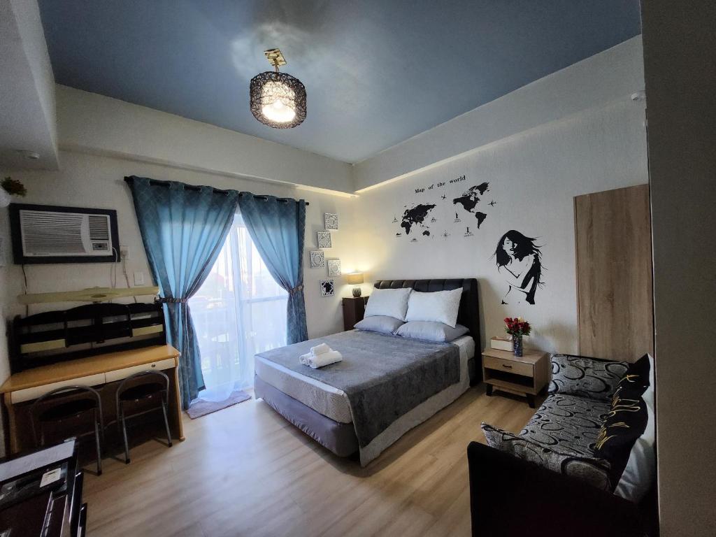 ein Schlafzimmer mit einem Bett, einem Fenster und einem Sofa in der Unterkunft Condo Azur Suites A326 Amani Resorts Residences , 5 minutes Airport, Netflix, Stylish, Cozy with Luxurious Swimming Pool in Pusok