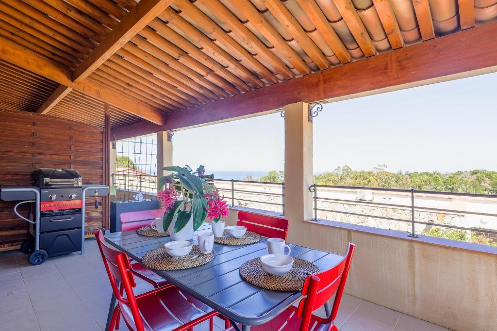 une salle à manger avec une table et des chaises rouges dans l'établissement Capra Scorsa - Appt vue mer et piscine partagée, à Belgodère