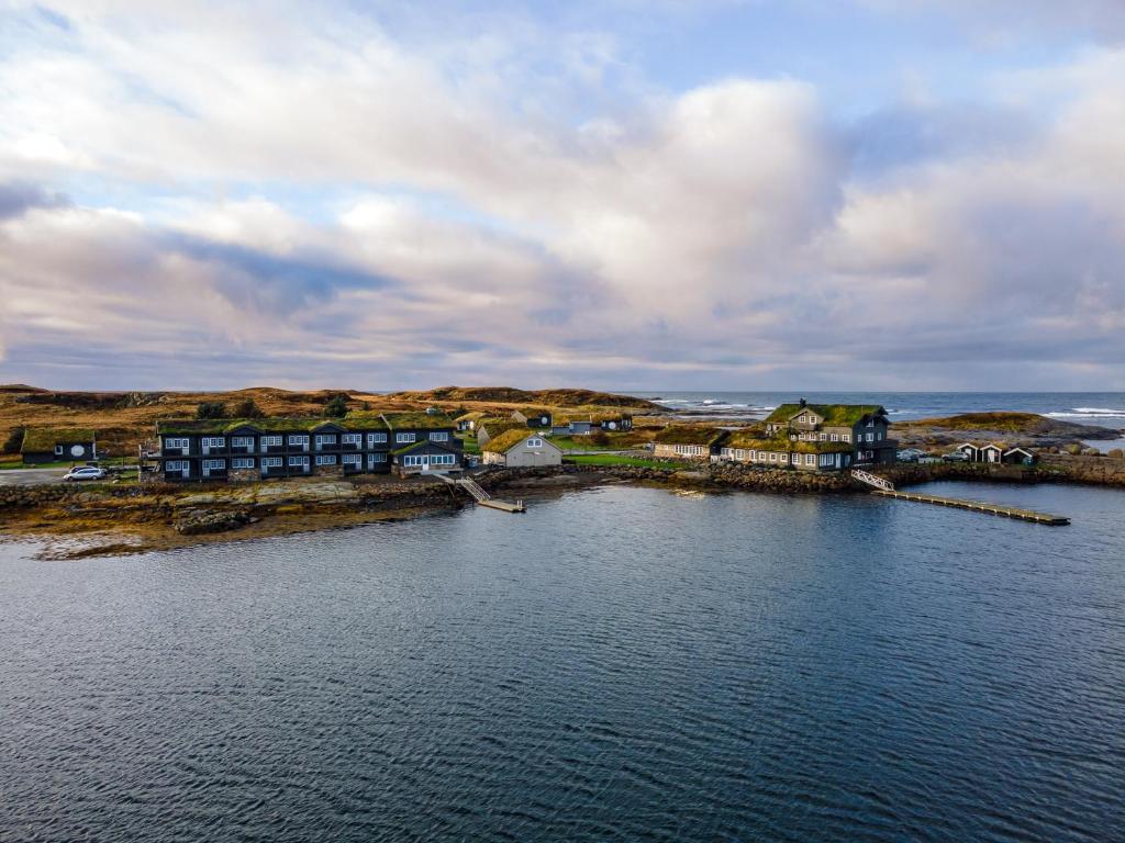 une vue aérienne d'une étendue d'eau avec des maisons dans l'établissement Hustadvika Havhotell - by Classic Norway Hotels, à Farstad
