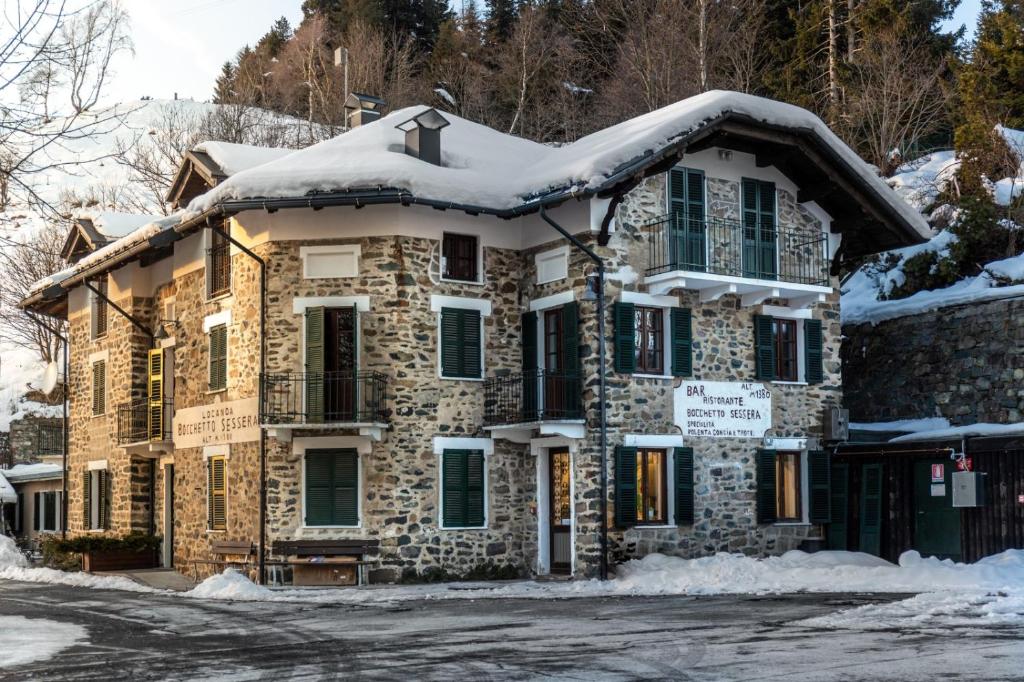 a stone house with snow on the roof at Locanda Bocchetto Sessera in Bielmonte