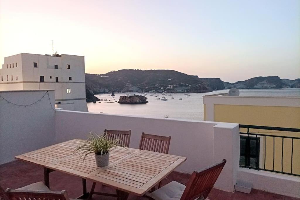 a wooden table on a balcony with a view of the water at ~ ~ Brezza Mediterranea ~ ~ in Ponza