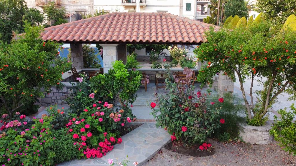 a garden with a gazebo with flowers and plants at Artemis Traditional Hotel in Myrina