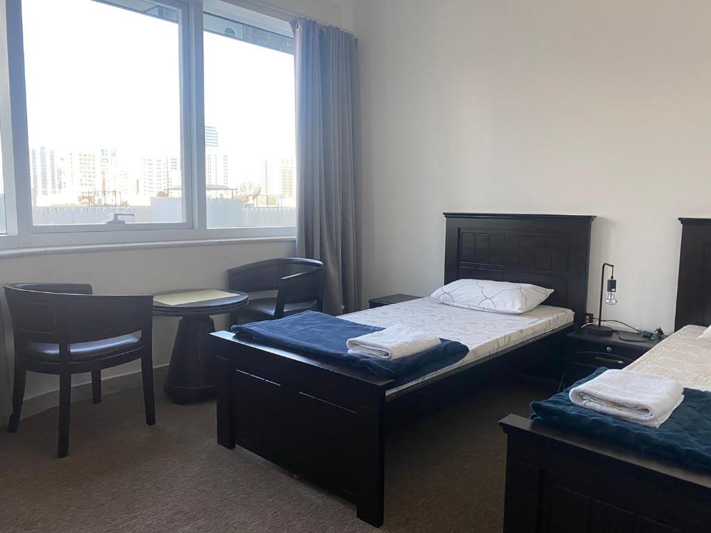 une chambre d'hôtel avec un lit, une table et des chaises dans l'établissement A Home Away From Home, à Abu Dhabi