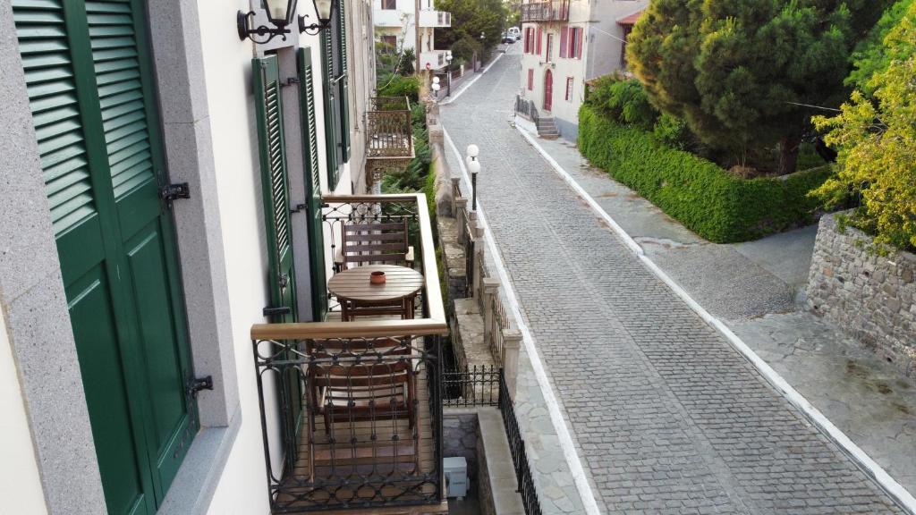 an empty balcony with a table and chairs on a street at Artemis Traditional Hotel in Myrina